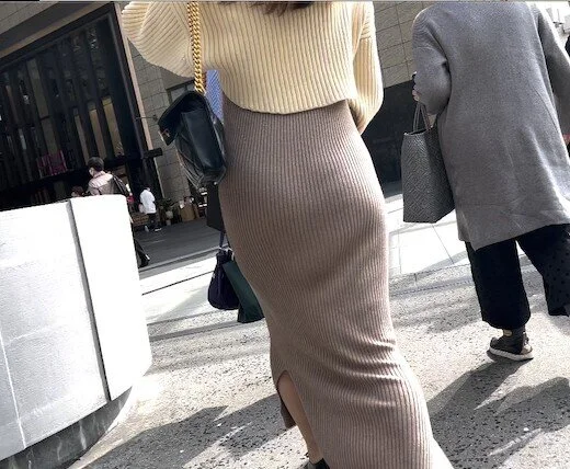 お尻の丸みが強調されたリブニットワンピで歩く20代きれい目女子