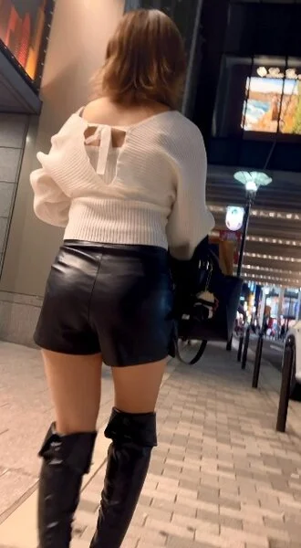 レザーショートパンツ姿で街を歩く美女